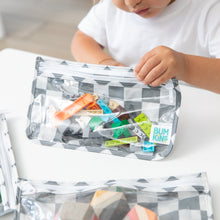 Load image into Gallery viewer, A child plays with colorful blocks in a Bumkins Clear Travel Bag 3 Pack: Charcoal Check at a white table.