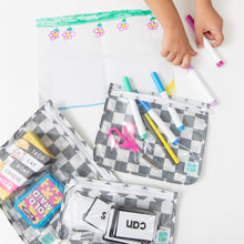 Load image into Gallery viewer, A child draws with markers as Bumkins Clear Travel Bag 3 Pack: Charcoal Check holds scissors, cards, and supplies on a white table.