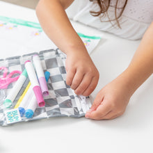 Load image into Gallery viewer, A child unzips a Bumkins Clear Travel Bag 3 Pack: Charcoal Check filled with colorful markers at a white table.