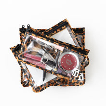 Load image into Gallery viewer, Roamio by Bumkins Clear Travel Bag 3 Pack: Leopard is stacked on a white background, filled with cosmetics.