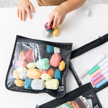 Load image into Gallery viewer, A child plays with a toy car at a white table while Bumkins Clear Travel Bag 3 Pack: Rich Black hold blocks and markers nearby.