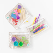 Load image into Gallery viewer, Bumkins Clear Travel Bag 3-Pack: Wander holds foam flowers, popsicle sticks, scissors, pens, clay, and cookie cutters on a white background.
