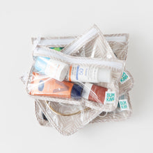Load image into Gallery viewer, Bumkins Clear Travel Bag 3-Pack: Wander lays stacked on a white background with toiletries inside.