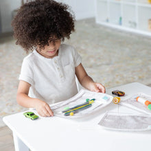Load image into Gallery viewer, A child with curly hair plays with toys and art supplies in Bumkins Clear Travel Bag 3-Pack: Wander on a white table in a bright room.