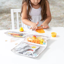 Load image into Gallery viewer, A child enjoys modeling clay and art supplies at a white table with Bumkins Clear Travel Bag 3-Pack: Wander.