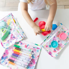 Load image into Gallery viewer, A child plays with colorful dough and tools on a white table, surrounded by art supplies in Bumkins Clear Travel Bag 3-Pack: Watercolor.