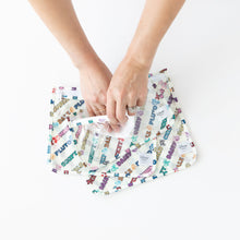 Load image into Gallery viewer, Hands wipe the interior of Bumkins Clear Travel Bag 3 Pack: Mickey & Friends Varsity with a cloth on a white background.