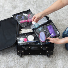 Load image into Gallery viewer, A person places toiletries into Bumkins Clear Travel Bag 3-Pack: Mickey Mouse Icon Black + White in a black suitcase on a gray carpet.