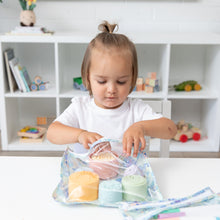 Load image into Gallery viewer, A toddler reaches into a Bumkins Clear Travel Bag 3 Pack: Aloha Stitch at a white table in front of shelves with toys and books.
