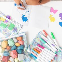Load image into Gallery viewer, A child draws with a blue marker amid colorful markers and craft supplies in Bumkins Clear Travel Bag 3 Pack: Aloha Stitch on a white table.