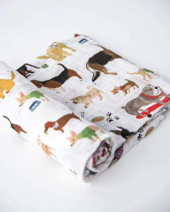 The Cotton Swaddle, Woof by Little Unicorn features colorful dogs—perfect as a baby swaddle blanket on any white surface.
