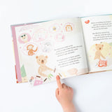 A childs hand points to Thinking of You by Slumberkins, featuring Honey Bear and animals, capturing winter gratitude.