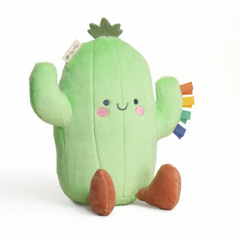Itzy Ritzy's Sweetie Snuggles Cactus: a green plush toy with a smile, brown feet, and rainbow ribbon tags for sensory fun.