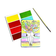 Load image into Gallery viewer, Desert Getaway DIY Watercolor Kit by OOLY: Paint a cow skull with flowers using red, yellow, and green on white canvas. Comes with a brush.