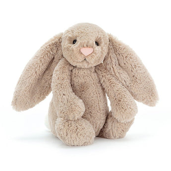 Jellycat Bashful Bunny Beige Medium, a plush toy with floppy ears and a pink nose, sits softly against a white background.
