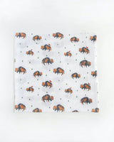 Little Unicorns Cotton Swaddle Set features white muslin with bison and green triangles, ideal for swaddling.
