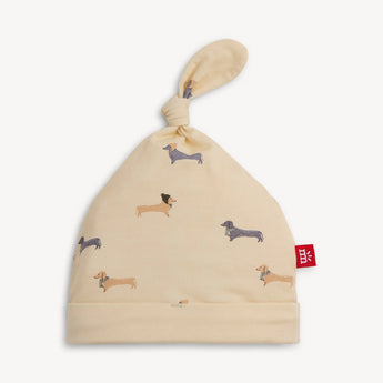 Magnetic Me Beenie Von Weinie Hat: cream modal, dachshund print, top knot & red tag—ideal for newborn's coming home outfit.