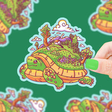 Load image into Gallery viewer, Vinyl Sticker, Tortoise Walking Island by Turtle Soup: Waterproof cartoon turtle with trees, house, and flowers on its shell.