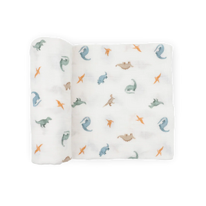 Little Unicorn Organic Cotton Muslin Swaddle Blanket - Little Dino: blue, green, orange & brown dino print, rolled on one side.