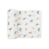 Little Unicorn Organic Cotton Muslin Swaddle Blanket - Little Dino: blue, green, orange & brown dino print, rolled on one side.
