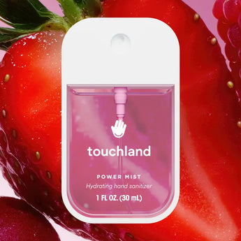 Hydrating Hand Sanitizer: pink sanitizer bottle with white cap & text "touchland Power Mist Hydrating hand sanitizer" on a strawberry half.