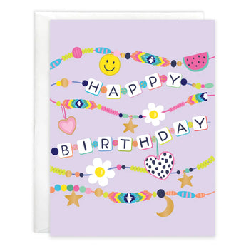 A Gina B Designs Birthday Card, Charm Bracelets folded on a light purple background with colorful beads and charms spelling the greeting.