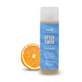 Vita C After Swim Shampoo, a chlorine neutralizer, stands next to a sliced orange on a white background.