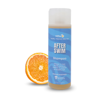 Vita C After Swim Shampoo, a chlorine neutralizer, stands next to a sliced orange on a white background.