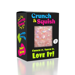 Showcase Crunch & Squish: Black box with window shows a pink, sparkly crunchy stress ball for sensory fidget and stress relief.