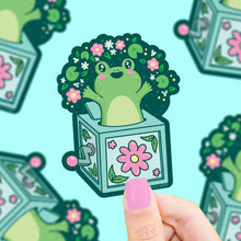 Load image into Gallery viewer, Turtle Soups Frog Jack In The Box vinyl sticker is waterproof and durable, featuring a green frog with a floral afro.
