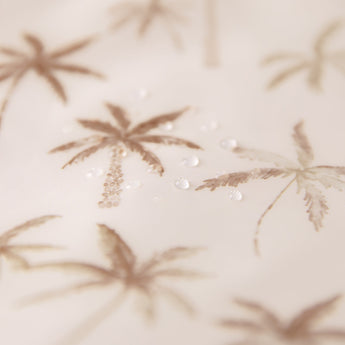 Close-up of water droplets on Bumkins Sleeved Bib: Palm Daze.