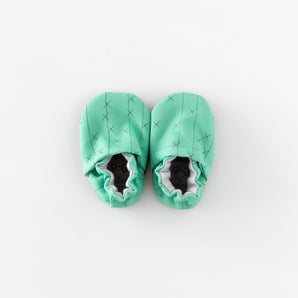 Cabooties Cactus Spines: Mint green baby booties with crisscross stitching and elastic closure, displayed on a white background.