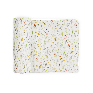 Little Unicorn Organic Cotton Muslin Swaddle—Floral Field: white with colorful wildflowers & green leaves, partially rolled.