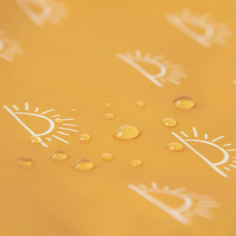 Close-up of water droplets on a yellow Bumkins Starter Bib 2 Pack: Sunshine and Grounded.