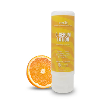 Vita C's C-Serum Anti Aging Lotion sits before a sliced orange, highlighting its antioxidant power for skin and hair care.