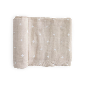 Little Unicorn Cotton Swaddle, Taupe Cross: breathable taupe muslin blanket with white crosses, neatly folded on a white background.