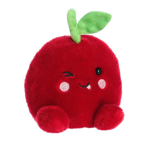Aurora Palm Pals Cordial Cherry: plush red apple toy with green leaf, winking face, pink cheeks, and plush feet.