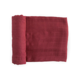 Deluxe Muslin Swaddle in Dusty Maroon by Little Unicorn, folded with a grid pattern and partially rolled on a white background.