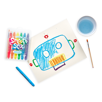 An OOLY robot uses Smooth Stix Watercolor Gel Crayons to draw on paper with a paintbrush nearby.