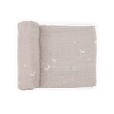 Little Unicorn Organic Cotton Muslin Swaddle- Moon Dust: light brown with white moons, stars & clouds, partially rolled.