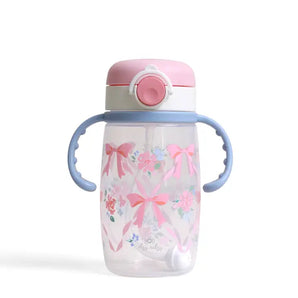 The Itzy Ritzy Itzy Sips Ribbons & Roses cup is clear with blue handles, a pink lid, and pink bows and flowers on the front.