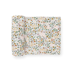 Little Unicorn Stretch Knit Swaddle Blanket in Pressed Petals: white with green, orange, and yellow floral print.