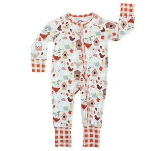 Sleeper, Cozy Cottage: white long sleeve pajamas with bird, house, & plant print, red plaid cuffs, & front zipper; made of bamboo viscose.