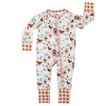 Sleeper, Cozy Cottage: white long sleeve pajamas with bird, house, & plant print, red plaid cuffs, & front zipper; made of bamboo viscose.