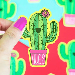 Hand holding Turtle Soups Vinyl Sticker, Hugs Potted Cacti, featuring a waterproof cactus with a pink flower against a colorful backdrop.