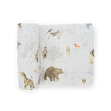Little Unicorn Cotton Swaddle, Party Animals: white muslin with blue dots & animal prints; breathable blanket, partially rolled up.