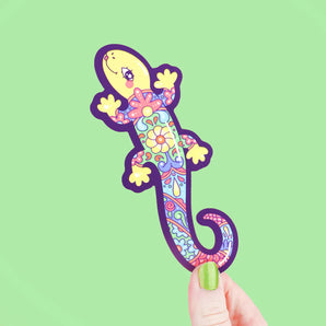 Bookmark, Talavera Lizard: lizard with colorful floral design, held by a hand with light green nails in front of a light green background.