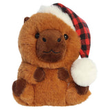 Aurora’s Corrina Capybara w/ Hat is a plush toy featuring a red and black checkered Santa hat with a fluffy white pom-pom.