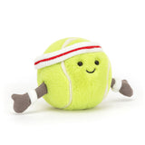 A smiling Jellycat Amuseables Sports Tennis Ball plush with brown arms and a white and red sweatband.