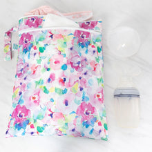 Load image into Gallery viewer, Bumkins Wet/Dry Bag: Watercolor filled with cloth diapers, placed next to a breast pump on a white marble surface.
